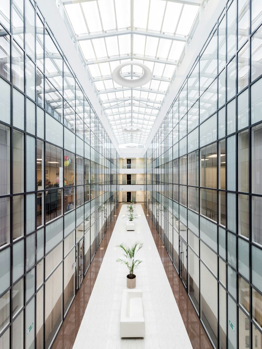 A bright open atrium walkway in a modern office building