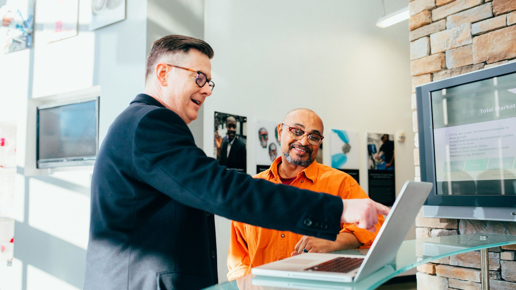 Two colleagues building and reviewing a system together on a laptop