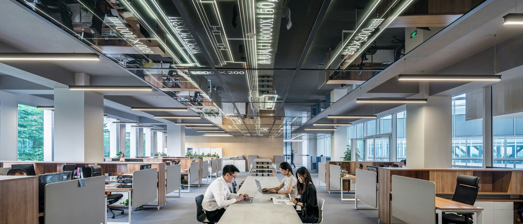 An open plan office floor with a team working at a shared table